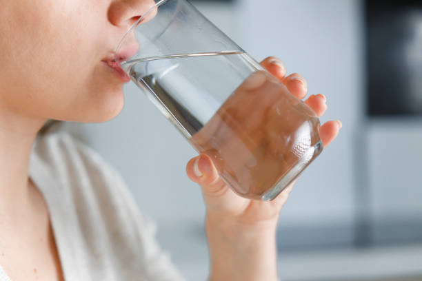 istock Woman drinking water at home 1389444178