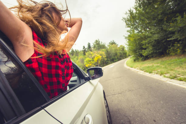 istock Woman with head up having fun on a windy day car drive 1389448539