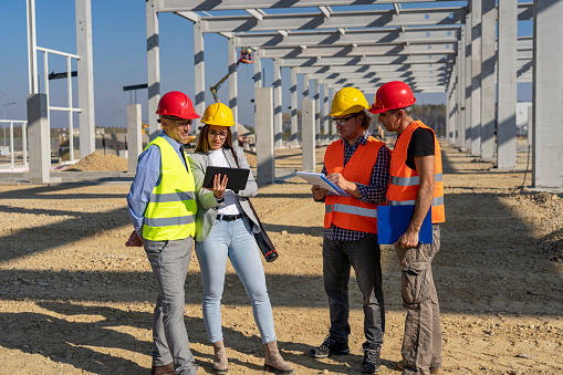 Project Management and Field Crew Meeting on Construction Site. Supervisor, Female Architect , Foreman and Construction Worker Having Conversation at Workplace.