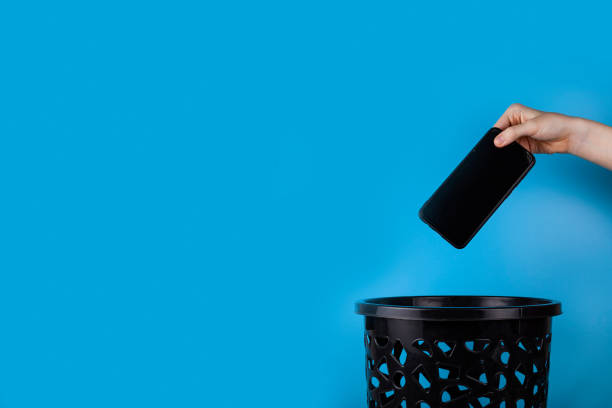 The smartphone is thrown into the trash for disposal and recycling