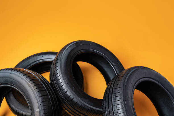 istock Car tires isolated on yellow background, close up 1389452603
