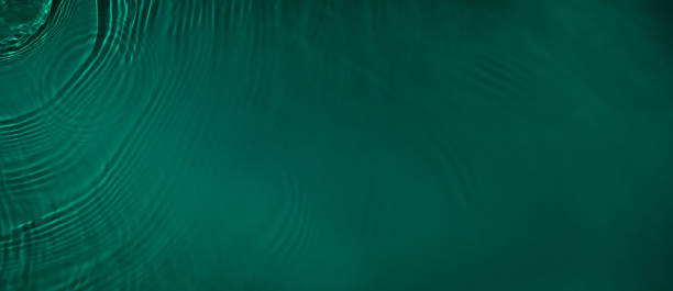 istock transparent dark green colored clear calm water surface texture 1389452612