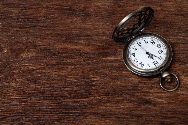 Vintage copper pocket clocks on dark wood background