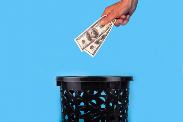 istock Dollars are thrown into the trash can. 1389453302