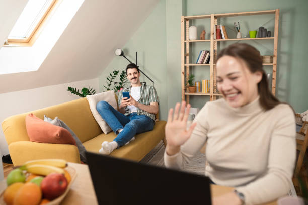 istock Happy woman having an online class while her husband surfing the net 1389453910