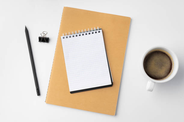 istock Cup of coffee and notepad on white background 1389454686