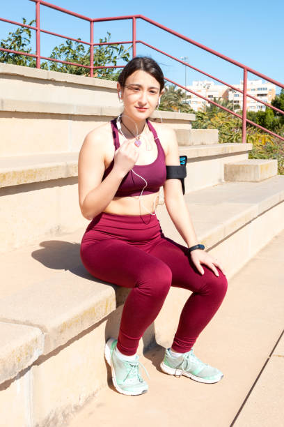 istock Girl athlete seated in a bleachers 1389455016