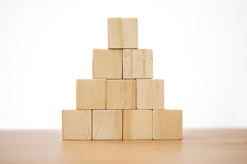 wooden cube block toy stacked in pyramid shape without graphics for Business design concept and activity for child foundation practice skills