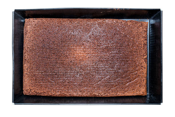 istock Baked cocoa cake lying in a baking sheet, isolated on a white background with clipping path, top view. 1389455307