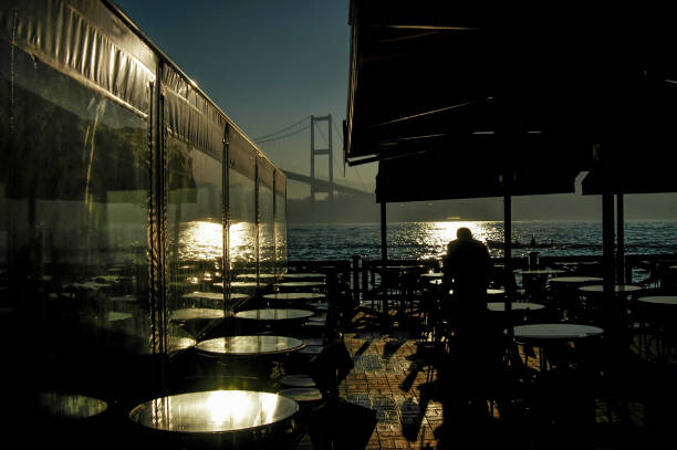 istock Waiter preparing breakfast under the Bosphorus Bridge in Istanbul 1389456123