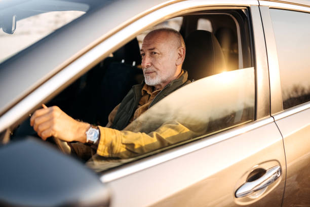 istock Handsome senior man driving car 1389456596