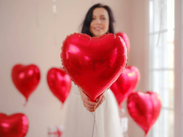 schöne glückliche junge frau, die den valentinstag feiert - model home house balloon sign stock-fotos und bilder