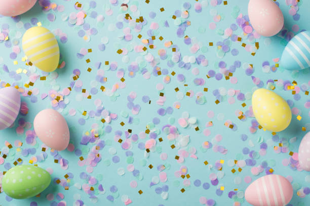 istock Top view photo of easter decorations multicolored easter eggs gold pink and violet confetti on isolated pastel blue background 1389457777