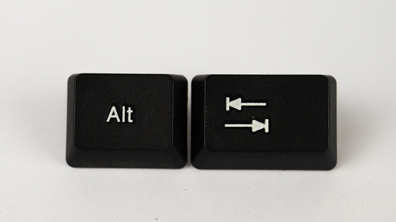 White Alt Tab on black keyboard, top view, Alt Tab shortcut text created with keyboard keys isolated on white background, computer terminology