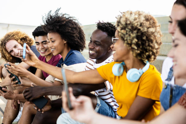 istock Young group of multiracial people using smartphone outdoors 1389459810