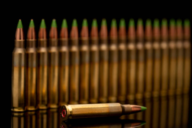 A group of 5.56 calibar, green tip bullets ordered into the line on black background
