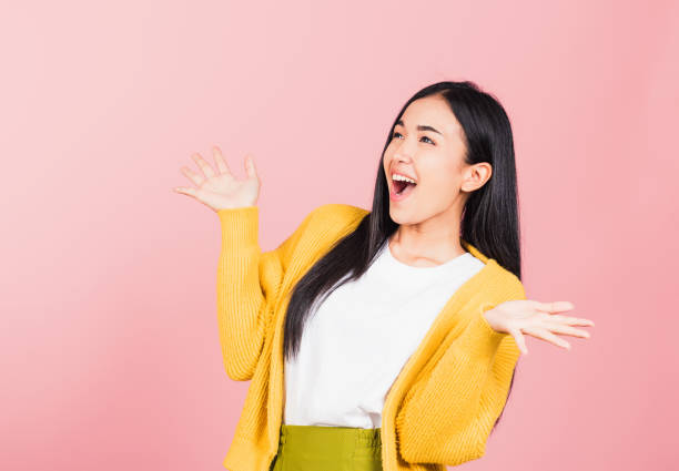 istock woman standing winning and surprised excited screaming 1389463486