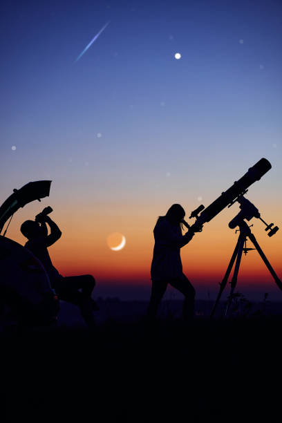 istock Couple stargazing together with a astronomical telescope. 1389463600
