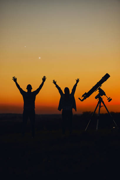 istock Couple stargazing together with a astronomical telescope. 1389463629