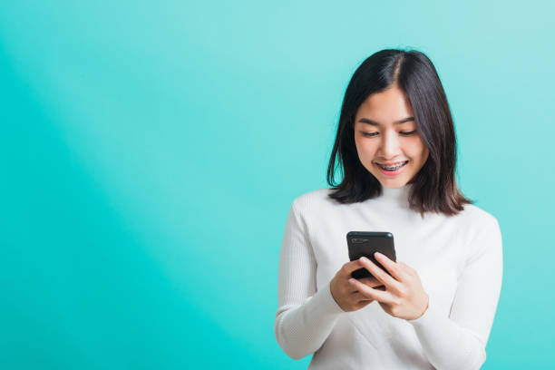 istock woman smile she holding and typing text message 1389463638