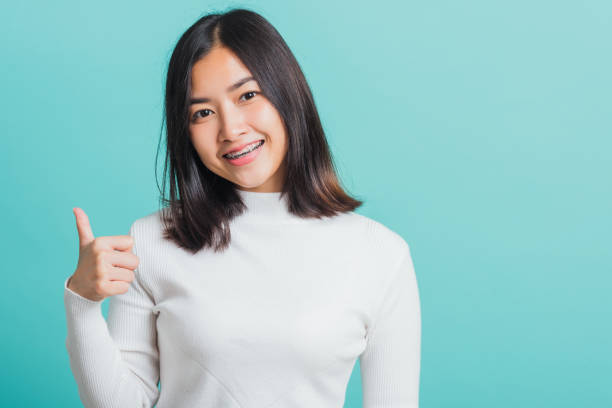 istock woman cheerful smiling showing finger thumb up 1389463639