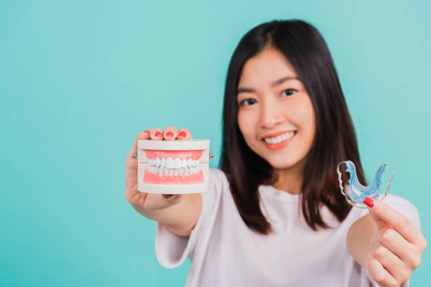 istock woman smiling holding silicone orthodontic retainers for teeth retaining 1389463658