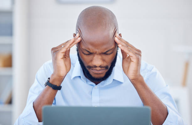 istock Shot of a young businessman suffering from a headache at work 1389465705