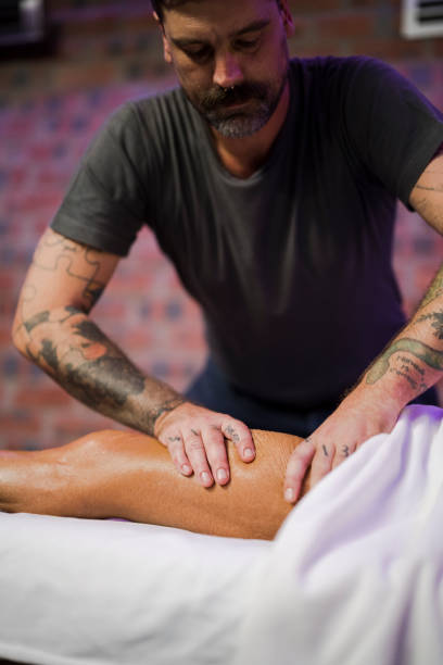 istock Medium shot of massage therapist massaging woman's calf 1389465772