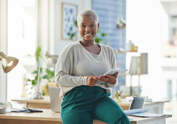 aufnahme einer jungen geschäftsfrau mit einem digitalen tablet in ihrem büro - business women computer cheerful stock-fotos und bilder