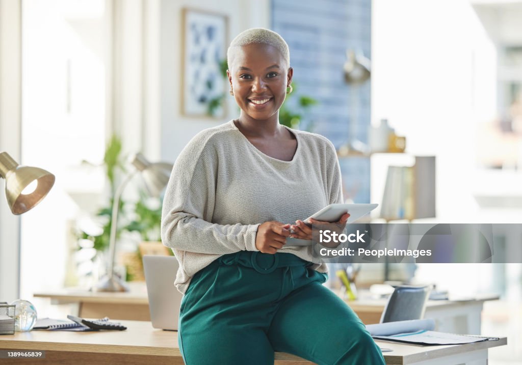 Shot of a young businesswoman using a digital tablet in her office Helping her connect to the world African Ethnicity Stock Photo