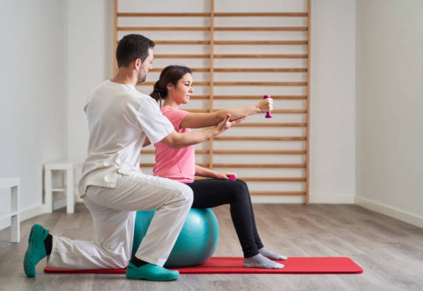 istock physiotherapist helping his patient to correct posture to avoid back pains 1389467572