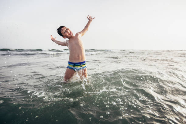 istock Happy child playing in the sea. 1389467590
