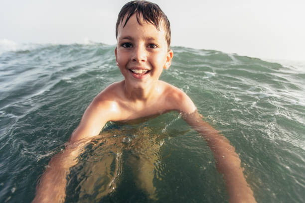 Happy child playing in the sea. Kid having fun outdoors. Summer vacation and healthy lifestyle concept. Selective focus