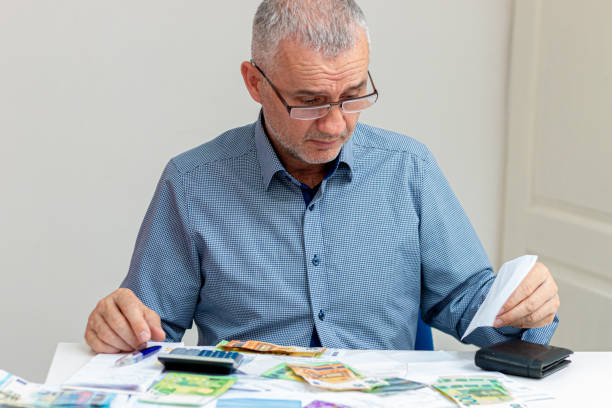 istock Businessman managing home family expenditures, using calculator. 1389468950