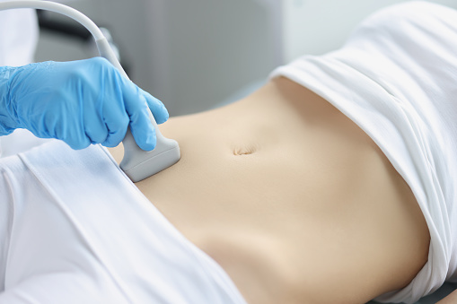 Manos en el estómago de una mujer, cavidad abdominal de ultrasonido photo