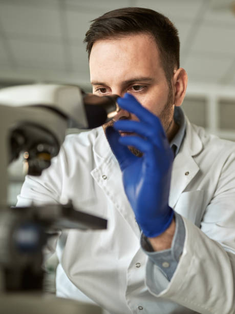 istock Young male scientist working on a microscope in laboratory. 1389471662