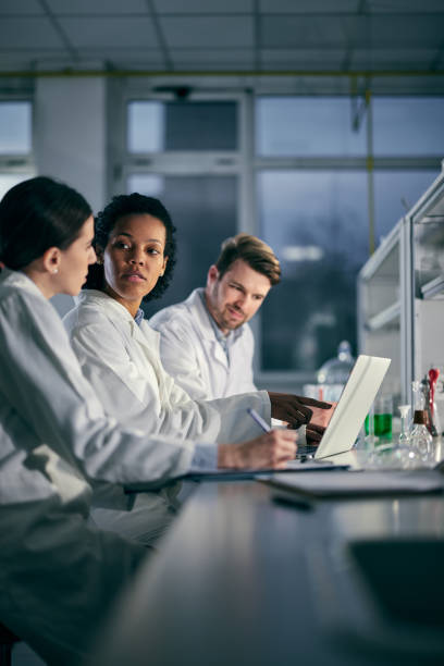 istock Team of young scientists working on a computer in laboratory. 1389471682
