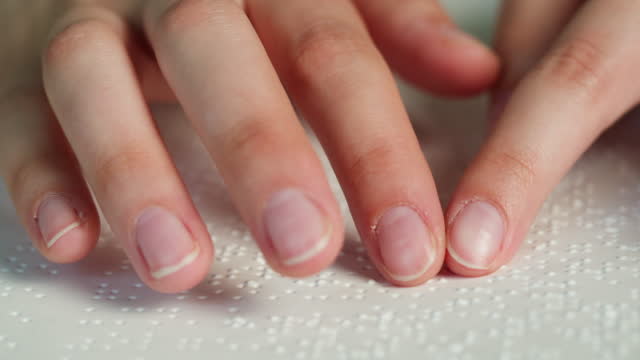 Blindman reading braille book using his fingers, poorly seeing person learning to read, education for people with disabilities. Close-up of touching letters on a sheet of paper