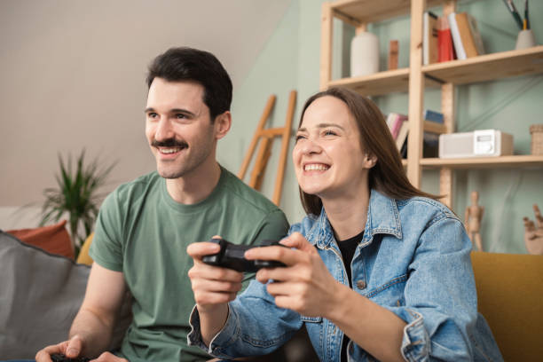 istock Happy couple gaming at home 1389474325