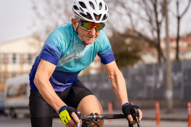 istock senior man on road bike, looking at camera 1389475839