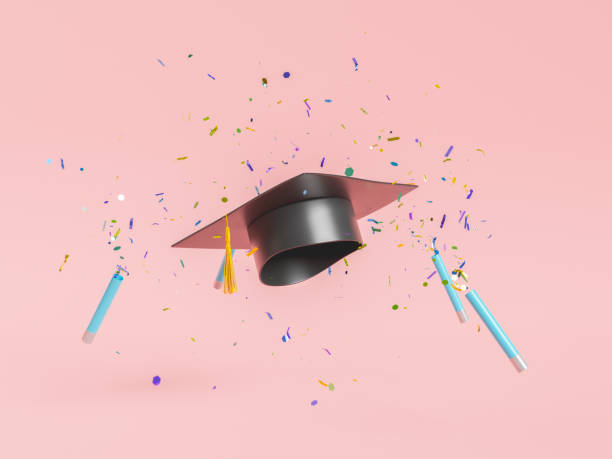 Graduation cap with colorful flying confetti on pink background stock photo