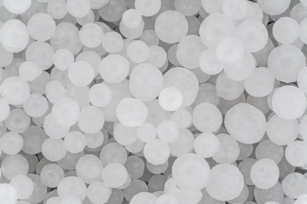 Photo of Sodium Hydroxide beads or lye - closeup detail to white granules, image width 19mm