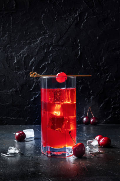 Cocktail garnished with cherry, fresh cranberry juice with ice Cocktail garnished with cherry, fresh cranberry juice with ice on a dark background, a highball glass with a place for text Gin stock pictures, royalty-free photos & images