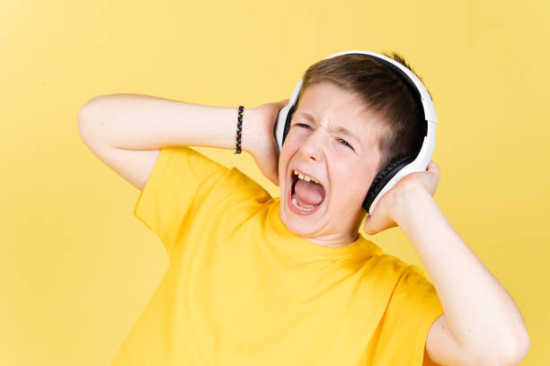 istock Boy singing out loud isolated on yellow background 1389479327