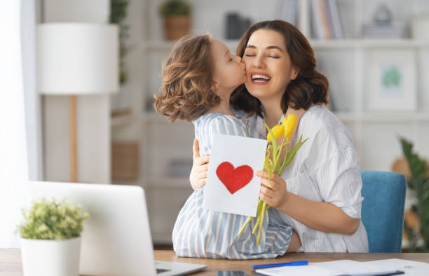 Happy mother's day Happy mother's day. Child daughter congratulating mom and giving her flowers and card. Mum and girl smiling and hugging. Family holiday and togetherness. small bunch of flowers stock pictures, royalty-free photos & images