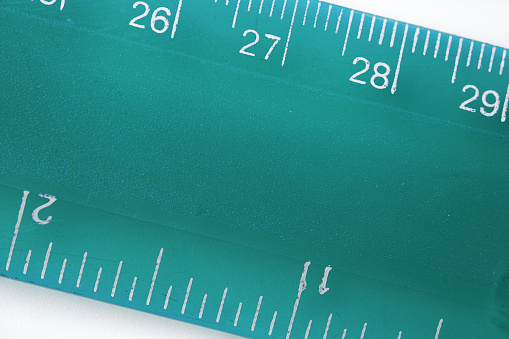 Selective focus a part of the plastic green transparent precision measurement tool. Centimetre, inch, millimeter. Measurement and comparison