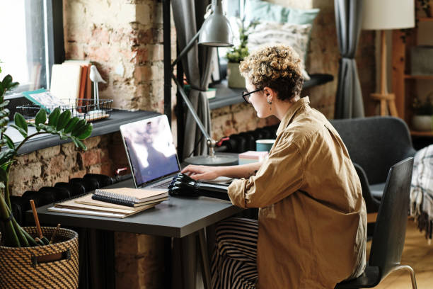 istock Woman with bionic arm working on laptop 1389481858