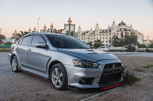 Side, Turkey – February 02 2022:  silver Mitsubishi Lancer    is parked  on the street on a warm  autumn  day against the backdrop of a street, hotel