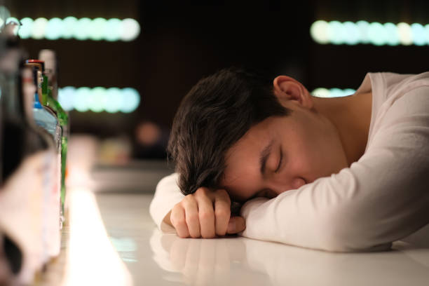 istock handsome Asian young man drunk on bar counter 1389482489