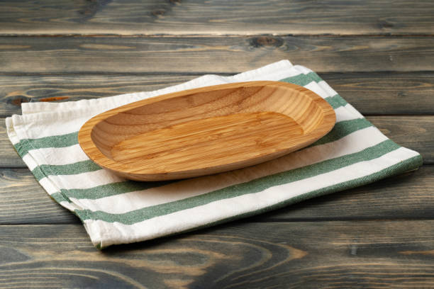 istock Wooden board with kitchen napkin on dark wooden table 1389483208